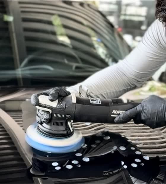 Technician machine polishing car paint with a Rupes polisher